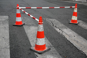 C&ocirc;nes de signalisation encadrant un passage pi&eacute;ton