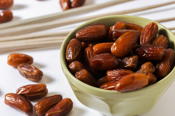 Fresh Organic Dates in Green Bowl with Palm Leaves