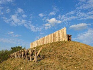 A wooden fence on a grassy hill