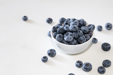 Blueberry is tasty, healthy and delicious fruits. Fresh blueberries  in white bowl. Wild blueberries in white plate on white background.