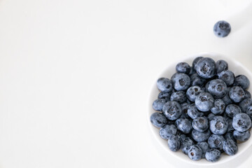 Blueberry is tasty, healthy and delicious fruits. Fresh blueberries heap in white bowl. Wild blueberries in plate with copy space for background.
