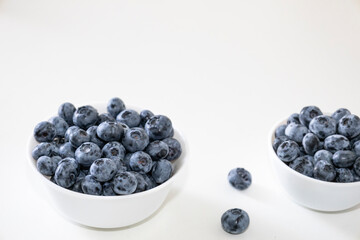 Blueberry is tasty, healthy and delicious fruits. Fresh blueberries  in white bowl. Wild blueberries in white plates on white background.