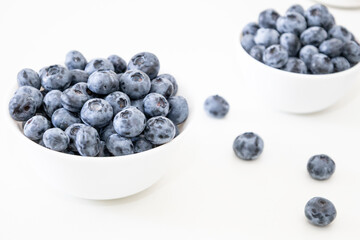 Blueberry is tasty, healthy and delicious fruits. Fresh blueberries  in white bowl. Wild blueberries in white plates on white background.