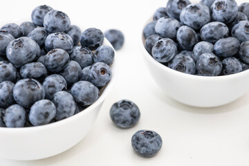 Blueberry is tasty, healthy and delicious fruits. Fresh blueberries  in white bowl. Wild blueberries in white plates on white background.