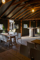Exposed beam ceiling with lantern lighting and wooden furniture in rustic restaurant dining room