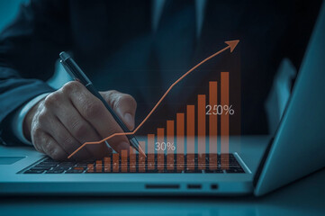 Hand with a pen analyzing a financial business growth chart on a laptop screen