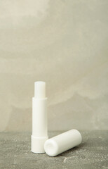 Lip balm on light background. Vertical photo