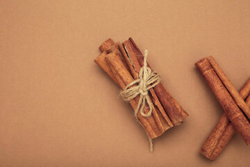 Cinnamon sticks dried tree bark spice on brown background.