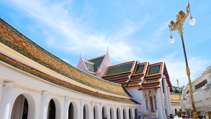 Obraz premium Beautiful temple architecture with arched walkway and traditional tiled roof in Thailand
