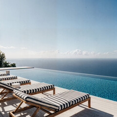 Obraz premium Modern infinity pool deck with teak sun loungers and panoramic island view