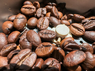 A pile of coffee beans with a piece of chocolate in the middle