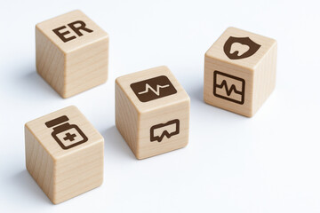 Wooden blocks with healthcare symbols including ER, medicine bottle, heartbeat, dental care, and medical chart represent benefit of organized health information and emergency readiness