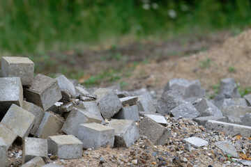 Pile of broken pavement tiles mixed with sand and construction debris