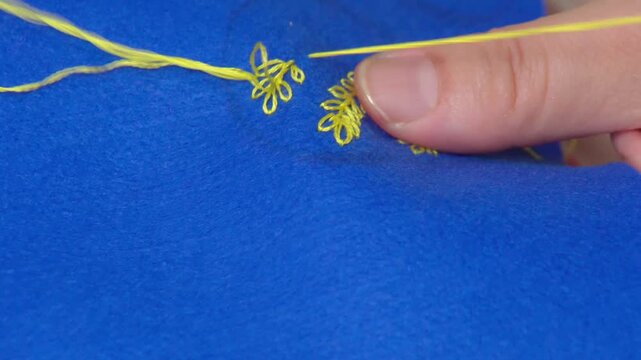 アクセサリーを手作りする女性の手元のクローズアローズアップ。葉っぱのモチーフを刺繍する様子。