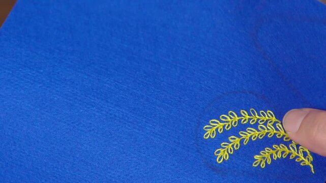 アクセサリーを手作りする女性の手元のクローズアローズアップ。葉っぱのモチーフを刺繍する様子。