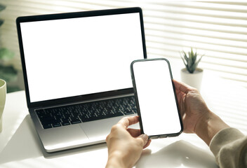 Responsive mockup laptop and smartphone blank screen on desk, cross-device template for website UI, app design, presentation and digital advertising with copy space for branding