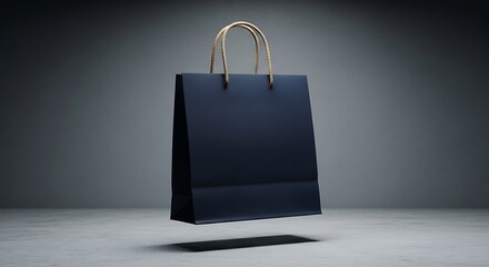 Elegant navy blue shopping bag with gold handles on a clean gray backdrop