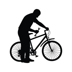 Obraz premium Silhouette of a man repairing a bicycle with a wrench bike maintenance cycling repair