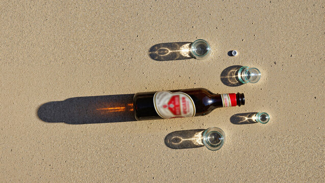 Beer bottle and glasses on a sandy surface World Sobriety Day and the fight against alcoholism