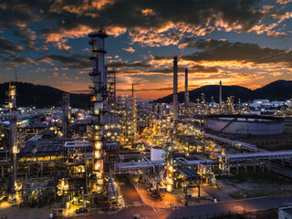 Obraz premium Oil refinery plant industry factory zone, oil and gas petrochemical industrial, oil storage tank and pipeline steel, twilight scene and over lighting equipment and the sunset and cloud sky background,