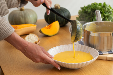 Cozy autumn meal preparation with pumpkin soup and fresh ingredients. Vegan meal