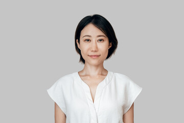 Isolated headshot closeup portrait of Eastern confident proud mature middle age leader ceo manager female businesswoman. Beautiful Asian young business sale woman looking at camera on grey background