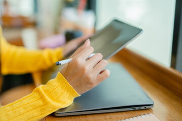  Young Asian professional businesswoman using laptop to manage marketing and using computer to manage digital data and sitting in modern office.