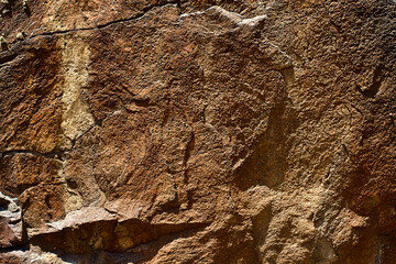 Close-up of sandstone or volcanic tuff rock with cracks, natural relief, and mineral details, Boshkyzylsay, Uzbekistan, July 2025.