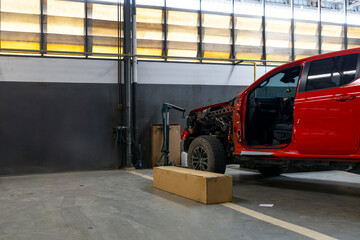 Red off-road vehicle under repair in spacious auto garage with parts and tools on concrete floor © memorystockphoto