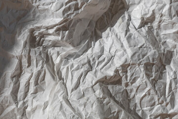 close-up of the texture of crumpled white wrapping paper, light and shadow on the paper