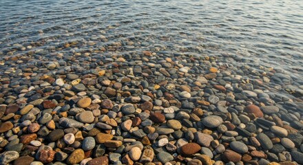 Pebblestrewn shoreline beneath gentle water ripples