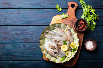  Raw shrimps in a plate on the dark blue background copy space for text