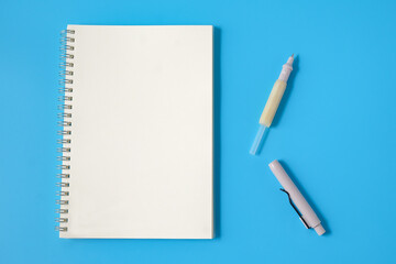 Notebook and broken pen on background.