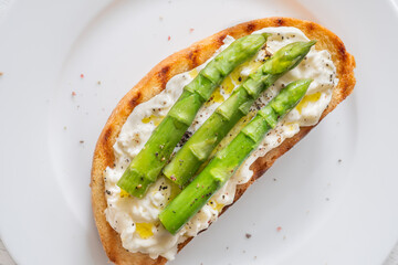 Grilled sandwich with white bread, stracciatella cheese, and green asparagus