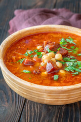 Rustic bowl of Spanish chorizo tomato chickpeas soup topped with cilantro
