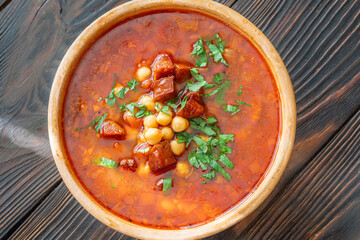 Rustic bowl of Spanish chorizo tomato chickpeas soup topped with cilantro