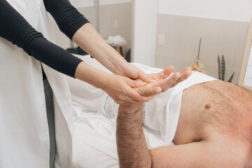 Massoterapeuta Feminina Realizando Massagem Tailandesa em Mão de Homem
