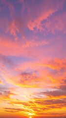 Obraz premium A breathtaking sunset over the ocean, with vibrant hues of orange, pink, and purple reflecting on the water, while fluffy clouds drift lazily above.