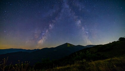 Milky way arch over mountain range at night