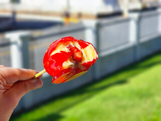 close-up photo of hand holding open Brazilian strawberry of love candy - morango do amor