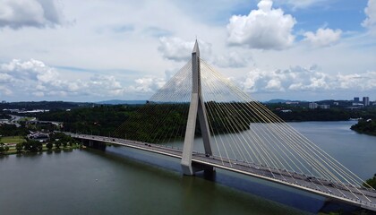 Obraz premium A suspension bridge spans a calm body of water.