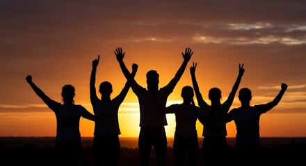 Fototapeta premium A silhouetted group celebrates together at sunset with arms raised in joy and triumph.
