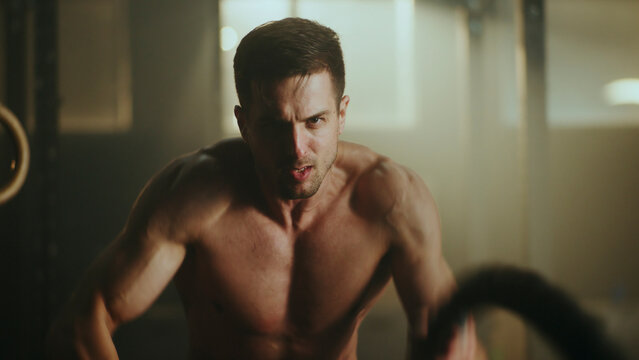 Determined male athlete lifting heavy weights in gym