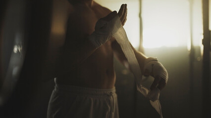 Boxer wrapping hands getting ready for training in locker room