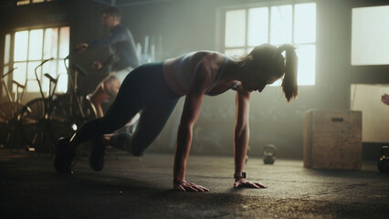 Determined sportswoman doing mountain climbers exercise in gym