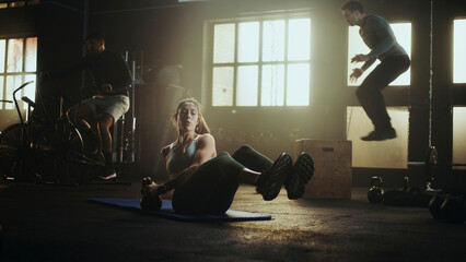 Determined sportswoman performing russian twist with kettlebell in gym