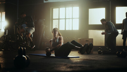 Determined sportswoman doing russian twist exercise with kettlebell in gym