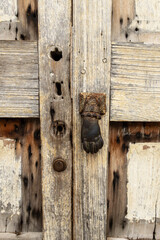 Detalle de puerta de madera con aldaba o llamador en forma de mano