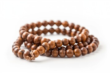 Obraz premium Wooden mala beads coiled on white background, spiritual meditation accessory.