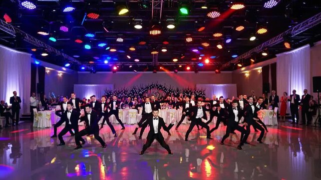 Groom and groomsmen dancing energetically at wedding reception
